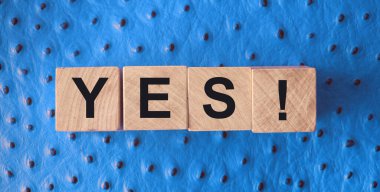 Evet kelimesi tahta bloklara siyah harflerle yazılmış. kırmızı deri arka planda. İş, motivasyon ve eğitim kavramı.