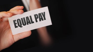 Kartvizitte eşit ödeme yazan bir işadamı. Cinsiyet eşitliği iş konsepti.