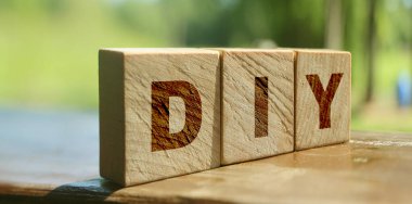 Ahşap küp bloklar ve kırmızı arka planda DIY harfleri. Doğayla iç içe iş kavramı