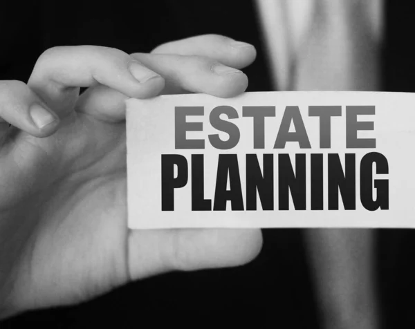 Estate Planning words on card a businessman shows. Real estate business concept.