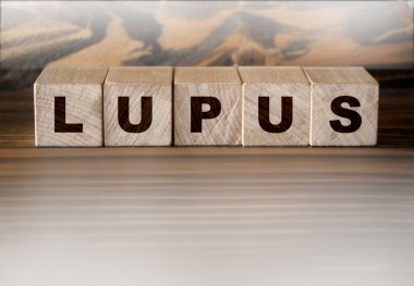 Lupus, tabletlerin ve termometrenin yanındaki mavi arkaplanda yazılı. İlaçlar. Yüksek kalite fotoğraf