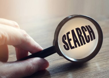 Elinde büyüteçle arama yap. SEO işletmesi veya arama yatırım konsepti.