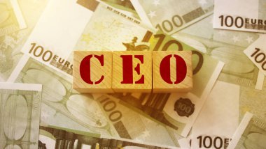 CEO 100 Euro 'luk banknotların üzerine tahta bir küpün üzerine yazılmış. Mektuplar Genel Müdür 'ün kısaltması. İş yönetimi kavramı.