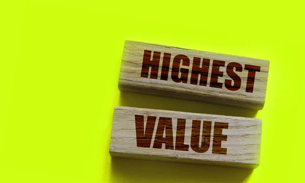 Highest values words on wooden building blocks isolated on yellow. Social, business and education concept.