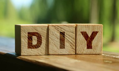 Ahşap küp bloklar ve kırmızı arka planda DIY harfleri. Doğayla iç içe iş kavramı