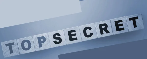 words Top secret on wooden cubes on green background. Trading or big profit secrets business concept.