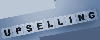 Yeşil eğimli arka planda tahta küplerle ilgili kelime UPSELING. İş konsepti.