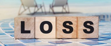 Kelimesi kelimesine kayıp plaj manzaralı tahta küpler. Finansal kayıp ya da kazançsız iş girişimleri kavramı.