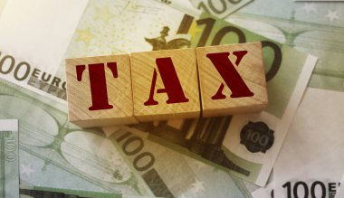 Tahta bloklar ve vergi 100 Euro 'luk banknotlar halinde. Vergi finans muhasebe kavramı.