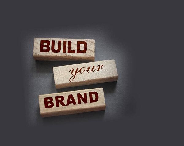 Фраза BUILD YOUR BRAND написана на деревянных блоках. С винтажным стилем. Рекламная концепция ребрендинга.