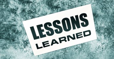 Ahşap arka planda öğrenilen mesajlarla dolu boş bir kart. İş konsepti.