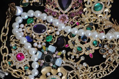 Zümrüt değerli taşlı klasik broşürler. Farklı renklerde cam ve metal broşlar. Renkli ve moda broşları. Lüks bir geçmişi var. Seçici odak