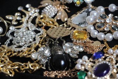 Zümrüt değerli taşlı klasik broşürler. Farklı renklerde cam ve metal broşlar. Renkli ve moda broşları. Lüks bir geçmişi var. Seçici odak