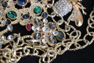 Zümrüt değerli taşlı klasik broşürler. Farklı renklerde cam ve metal broşlar. Renkli ve moda broşları. Lüks bir geçmişi var. Seçici odak