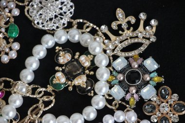 Zümrüt değerli taşlı klasik broşürler. Farklı renklerde cam ve metal broşlar. Renkli ve moda broşları. Lüks bir geçmişi var. Seçici odak