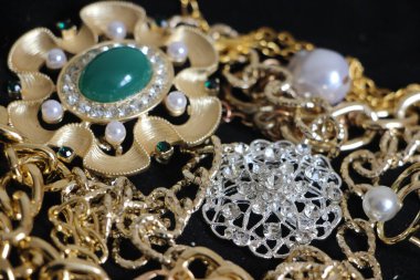 Zümrüt değerli taşlı klasik broşürler. Farklı renklerde cam ve metal broşlar. Renkli ve moda broşları. Lüks bir geçmişi var. Seçici odak