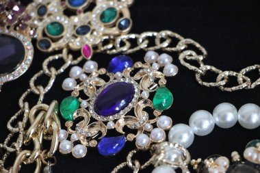 Zümrüt değerli taşlı klasik broşürler. Farklı renklerde cam ve metal broşlar. Renkli ve moda broşları. Lüks bir geçmişi var. Seçici odak