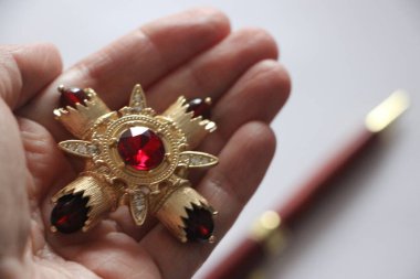 Zümrüt değerli taşlı klasik broşürler. Farklı renklerde cam ve metal broşlar. Renkli ve moda broşları. Lüks bir geçmişi var. Seçici odak