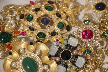 Zümrüt değerli taşlı klasik broşürler. Farklı renklerde cam ve metal broşlar. Renkli ve moda broşları. Lüks bir geçmişi var. Seçici odak