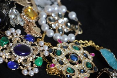 Zümrüt değerli taşlı klasik broşürler. Farklı renklerde cam ve metal broşlar. Renkli ve moda broşları. Lüks bir geçmişi var. Seçici odak