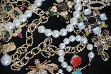 Zümrüt değerli taşlı klasik broşürler. Farklı renklerde cam ve metal broşlar. Renkli ve moda broşları. Lüks bir geçmişi var. Seçici odak