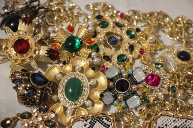 Zümrüt değerli taşlı klasik broşürler. Farklı renklerde cam ve metal broşlar. Renkli ve moda broşları. Lüks bir geçmişi var. Seçici odak