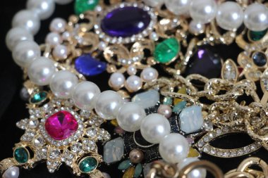 Zümrüt değerli taşlı klasik broşürler. Farklı renklerde cam ve metal broşlar. Renkli ve moda broşları. Lüks bir geçmişi var. Seçici odak