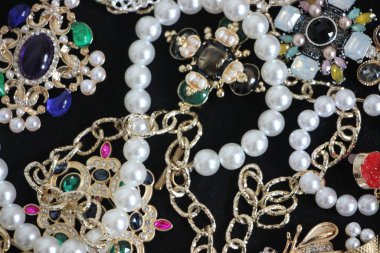 Zümrüt değerli taşlı klasik broşürler. Farklı renklerde cam ve metal broşlar. Renkli ve moda broşları. Lüks bir geçmişi var. Seçici odak