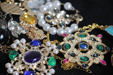 Zümrüt değerli taşlı klasik broşürler. Farklı renklerde cam ve metal broşlar. Renkli ve moda broşları. Lüks bir geçmişi var. Seçici odak