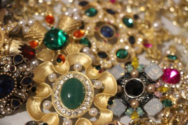 Zümrüt değerli taşlı klasik broşürler. Farklı renklerde cam ve metal broşlar. Renkli ve moda broşları. Lüks bir geçmişi var. Seçici odak