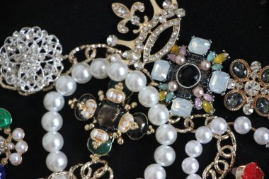 Zümrüt değerli taşlı klasik broşürler. Farklı renklerde cam ve metal broşlar. Renkli ve moda broşları. Lüks bir geçmişi var. Seçici odak