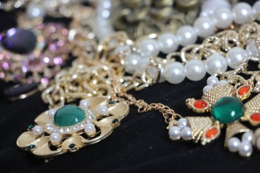 Zümrüt değerli taşlı klasik broşürler. Farklı renklerde cam ve metal broşlar. Renkli ve moda broşları. Lüks bir geçmişi var. Seçici odak