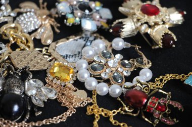 Zümrüt değerli taşlı klasik broşürler. Farklı renklerde cam ve metal broşlar. Renkli ve moda broşları. Lüks bir geçmişi var. Seçici odak