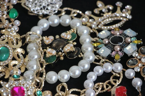 Zümrüt değerli taşlı klasik broşürler. Farklı renklerde cam ve metal broşlar. Renkli ve moda broşları. Lüks bir geçmişi var. Seçici odak