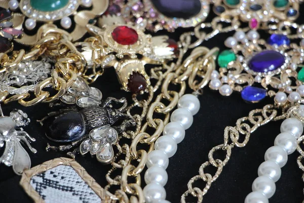 Zümrüt değerli taşlı klasik broşürler. Farklı renklerde cam ve metal broşlar. Renkli ve moda broşları. Lüks bir geçmişi var. Seçici odak