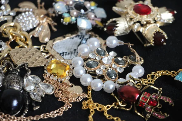 Zümrüt değerli taşlı klasik broşürler. Farklı renklerde cam ve metal broşlar. Renkli ve moda broşları. Lüks bir geçmişi var. Seçici odak