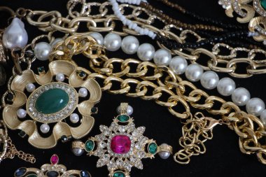 Zümrüt değerli taşlı klasik broşürler. Farklı renklerde cam ve metal broşlar. Renkli ve moda broşları. Lüks bir geçmişi var. Seçici odak