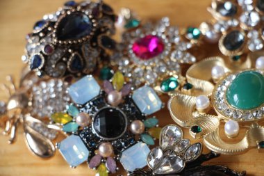 Zümrüt değerli taşlı klasik broşürler. Farklı renklerde cam ve metal broşlar. Renkli ve moda broşları. Lüks bir geçmişi var. Seçici odak