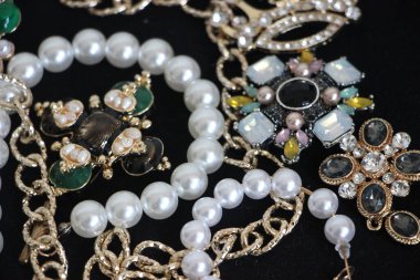 Zümrüt değerli taşlı klasik broşürler. Farklı renklerde cam ve metal broşlar. Renkli ve moda broşları. Lüks bir geçmişi var. Seçici odak