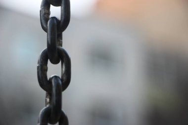 Endüstriyel arka planda gün ışığında eski kalın metal zincir.