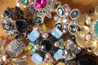 Zümrüt değerli taşlı klasik broşürler. Farklı renklerde cam ve metal broşlar. Renkli ve moda broşları. Lüks bir geçmişi var. Seçici odak