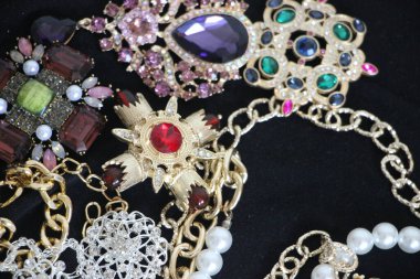 Zümrüt değerli taşlı klasik broşürler. Farklı renklerde cam ve metal broşlar. Renkli ve moda broşları. Lüks bir geçmişi var. Seçici odak