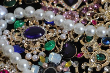 Zümrüt değerli taşlı klasik broşürler. Farklı renklerde cam ve metal broşlar. Renkli ve moda broşları. Lüks bir geçmişi var. Seçici odak