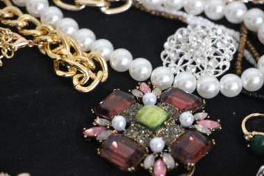 Zümrüt değerli taşlı klasik broşürler. Farklı renklerde cam ve metal broşlar. Renkli ve moda broşları. Lüks bir geçmişi var. Seçici odak