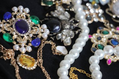 Zümrüt değerli taşlı klasik broşürler. Farklı renklerde cam ve metal broşlar. Renkli ve moda broşları. Lüks bir geçmişi var. Seçici odak