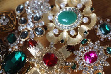 Zümrüt değerli taşlı klasik broşürler. Farklı renklerde cam ve metal broşlar. Renkli ve moda broşları. Lüks bir geçmişi var. Seçici odak