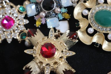 Zümrüt değerli taşlı klasik broşürler. Farklı renklerde cam ve metal broşlar. Renkli ve moda broşları. Lüks bir geçmişi var. Seçici odak