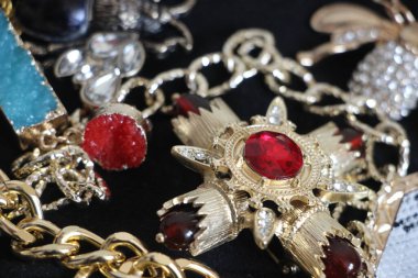 Zümrüt değerli taşlı klasik broşürler. Farklı renklerde cam ve metal broşlar. Renkli ve moda broşları. Lüks bir geçmişi var. Seçici odak