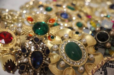 Zümrüt değerli taşlı klasik broşürler. Farklı renklerde cam ve metal broşlar. Renkli ve moda broşları. Lüks bir geçmişi var. Seçici odak