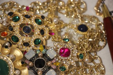 Zümrüt değerli taşlı klasik broşürler. Farklı renklerde cam ve metal broşlar. Renkli ve moda broşları. Lüks bir geçmişi var. Seçici odak